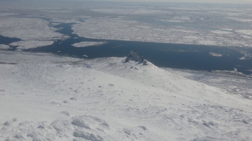 4 May 2014 - Looking down at the narrow strip of land fast ice present at the Cape. Open water exists along the shorefast ice edge and leads separate large floes.